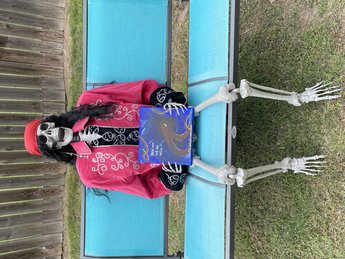 The Dead Pirate Robert. Head of Advertising. Image of plastic life size skeleton dressed as a pirate holding a painted sign with a Kraken. The sign reads "dead men tell no tales" and has the website www.thesaltyspinster.com on the bottom.