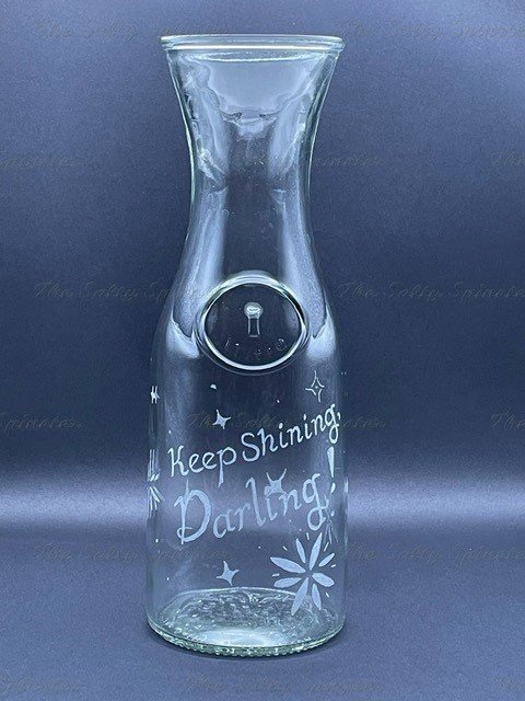 Hand Etched Glass Water Pitcher. Front face reads "Keep shining, Darling!" Retro-style stars etched around design.